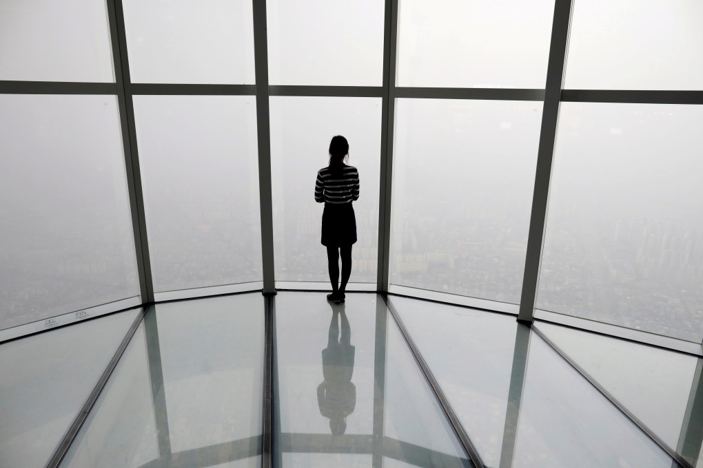 A woman looks at a view of Seoul shrouded by fine dust. Photo: Reuters