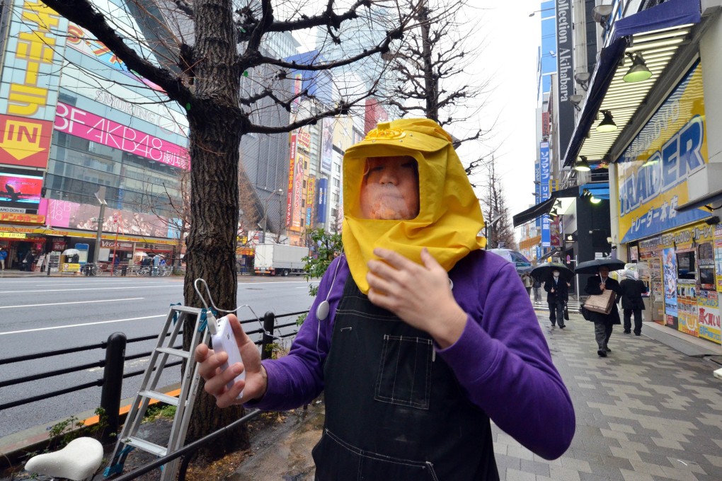 An employee of Japan’s novelty electronics shop Thanko wears a battery powered pollen protection hood or “kafun blocker” in Tokyo. Spring in Japan is beautiful, but it also heralds a mass outbreak of face masks and speciality goggles intended to fend off clouds of pollen that make noses stream and eyes itch. Photo: AFP