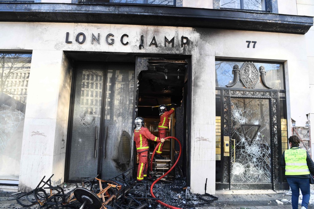 Firefighters extinguish a blaze in a Longchamp shop in Paris. Photo: EPA