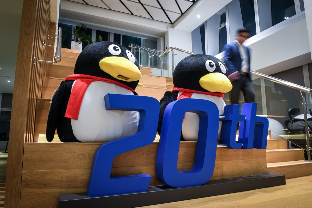 An employee walks past decorations for the 20th anniversary of the founding of Tencent Holdings at an office building in Shenzhen, Guangdong Province, on December 3, 2018. Photo: Xinhua