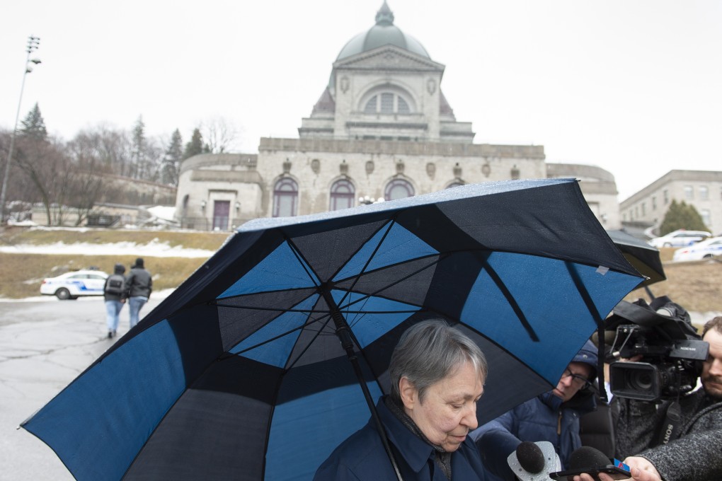 A woman talks to the media at the scene where a Catholic priest was stabbed at the St Joseph's Oratory in Montreal on Friday. Photo: AP