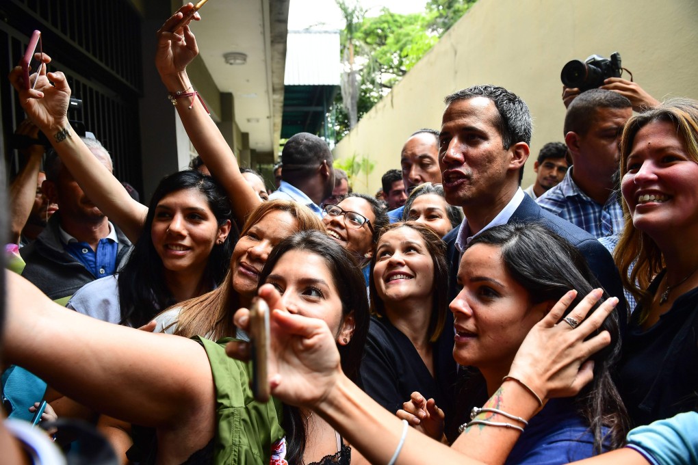 Venezuelan opposition leader and self-proclaimed interim president Juan Guaido poses for a picture with supporters. Photo: AFP