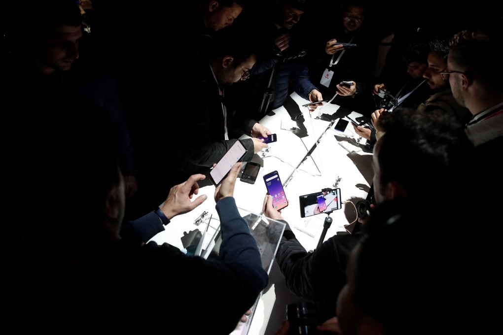 Visitors take a close view of Xiaomi Corp’s new Mi 9 and Mi Mix 3 5G handsets at a presentation on the eve of the MWC Barcelona trade show last month. Xiaomi, Oppo, Vivo and Huawei Technologies are each ratcheting up efforts in the premium segment of the global smartphone market with secondary brands. Photo: EPA-EFE