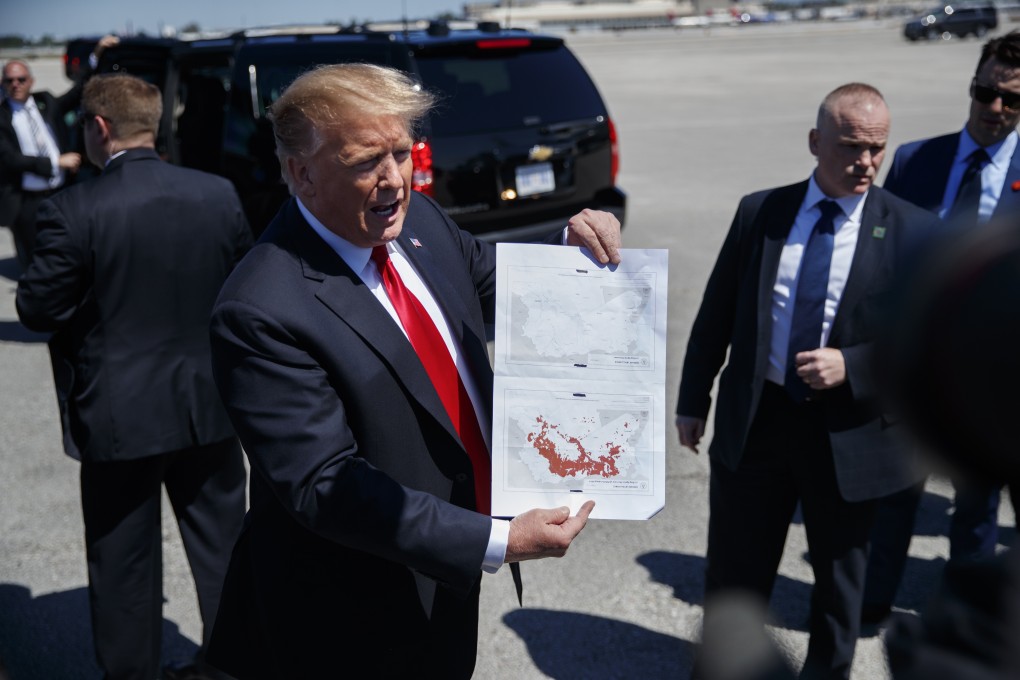 President Donald Trump holds a a copy of two maps of Syria as he arrives on Air Force One. Photo: AP Photo