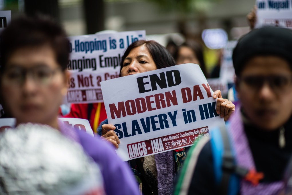 An activist from the Asian Migrants Coordinating Body holds a placard that reads ‘End Modern Day Slavery in HK’ during a protest on March 8. Photo: AFP
