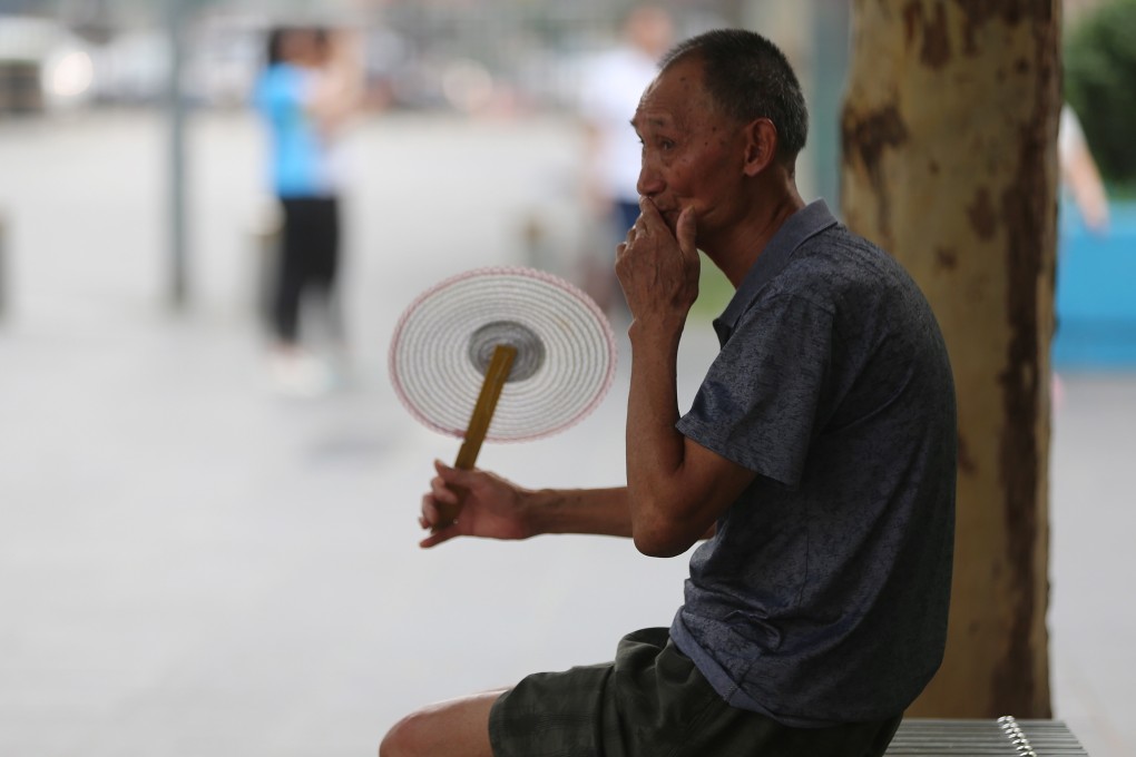 An elderly man fans himself during hot weather in Beijing. A strong cultural reliance on children rather than savings as well as lack of understanding about a convoluted system mean people are not saving enough for retirement. Photo: EPA-EFE