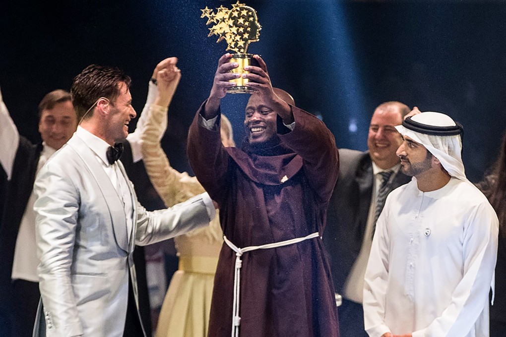 Kenyan teacher Peter Tabichi (C) holding up the Global Teacher Prize (GTP) trophy. Photo: AFP