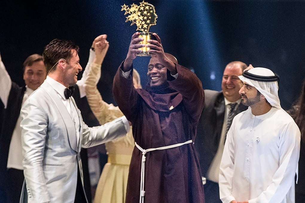 Kenyan teacher Peter Tabichi (C) holding up the Global Teacher Prize (GTP) trophy. Photo: AFP