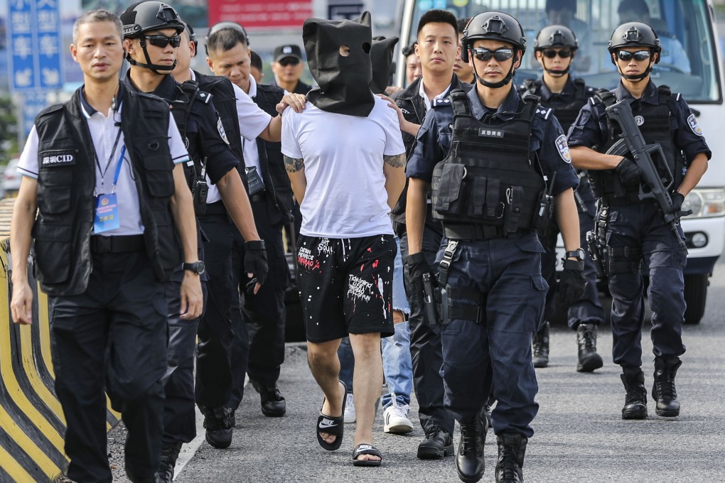Police from China’s Guangdong province hand over a suspect in a robbery case to Hong Kong officers at the Huanggang border checkpoint in July last year. Photo: Edward Wong