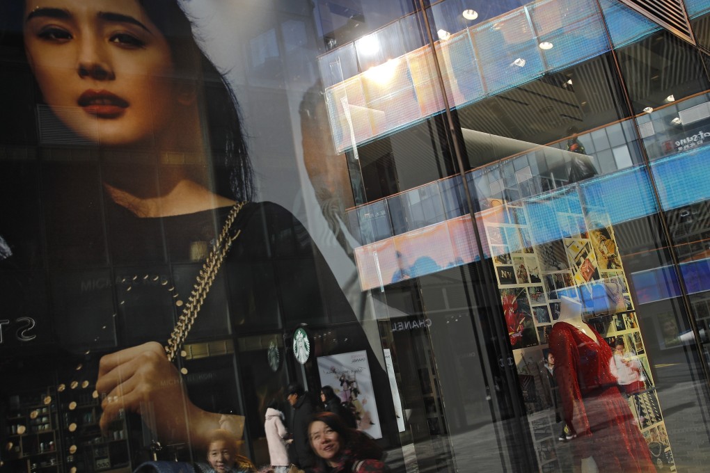 Shoppers peruse fashion boutique windows in a shopping mall in Beijing. Photo: AP