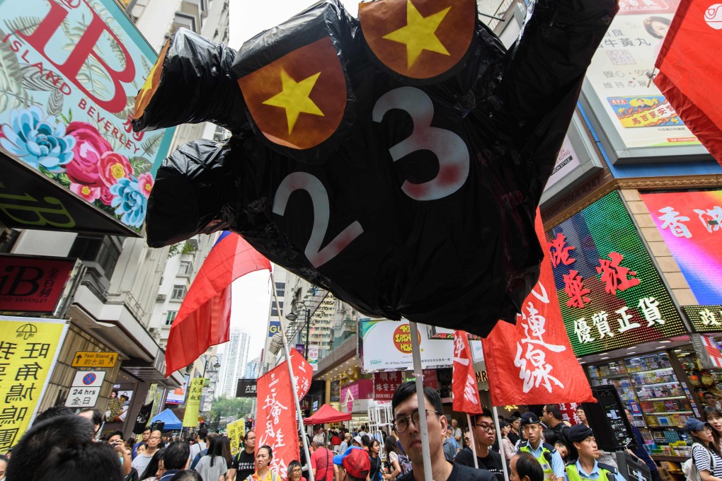 A protester holds up a hand-shaped prop adorned with the colours of the Chinese flag to protest about the possible enactment of Article 23 of the Basic Law at a rally in Hong Kong on October 1, 2018. NPC delegate Peter Wong’s support of national security legislation made him unpopular in some quarters. Photo: AFP