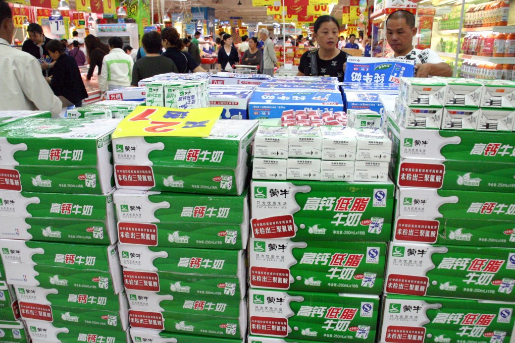 Chinese customers check out milk products at a store in Nanjing. Shares in Mengniu jumped 5.5 per cent to close at HK$27.95 in Hong Kong on Thursday, following the year-end results’ announcement. Photo: AFP