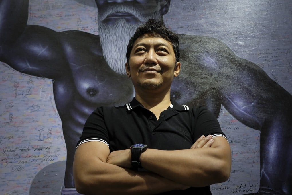 Indonesian artist I Nyoman Masriadi posing in front of his work Untitled Book (2019) during this year’s Art Basel Hong Kong at the Hong Kong Convention and Exhibition Centre. Photo: James Wendlinger