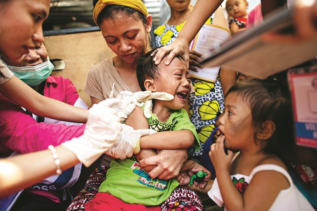 A child cries after being vaccinated against measles by the Philippine Red Cross in Baseco, a slum area in Manila, the Philippines. An outbreak of dengue fever now threatens the country amid a scandal over an anti-dengue vaccine. Photo: AFP