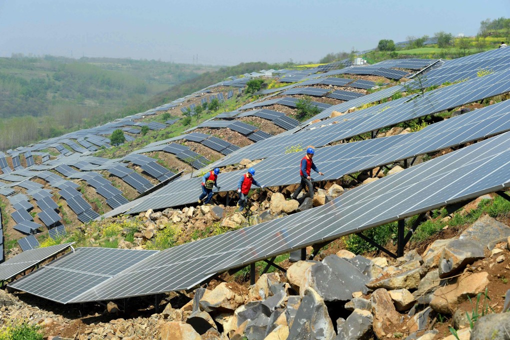 Workers check solar photovoltaic panels on a hillside in Anhui province, China. Solar panels are a key player in the fast-growing renewable energy sector, which also includes water- and wind-generated electricity. Photo: AFP