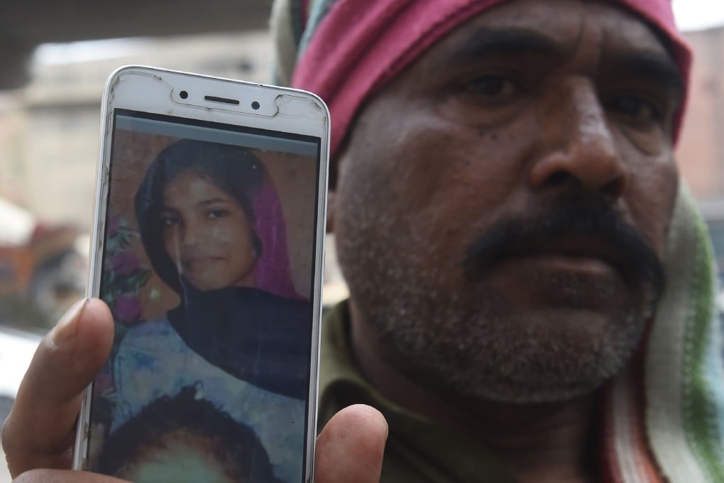 Muhammad Riaz shows a picture of his 16-year-old daughter, Uzma, who was found dumped in a city canal in Lahore. Photo: AFP