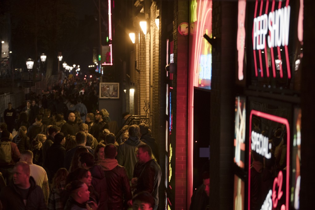 Tourists shuffle shoulder to shoulder through the narrow alleys of Amsterdam’s red light district. Photo: AP