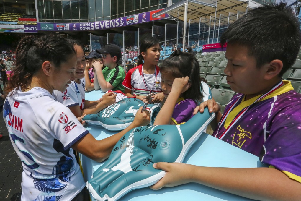 Hong Kong women’s players Sham Wai-sum and Melody Li sign autographs for fans on the first day of the Sevens at Hong Kong Stadium. Photo: Jonathan Wong
