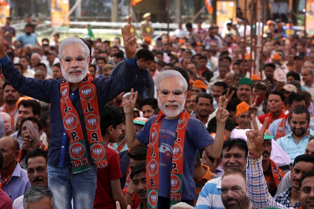 Supporters wearing Prime Minister Narendra Modi masks cheer as they attend a rally of his ruling Bharatiya Janata Party, near Jammu on April 3. Photo: EPA-EFE