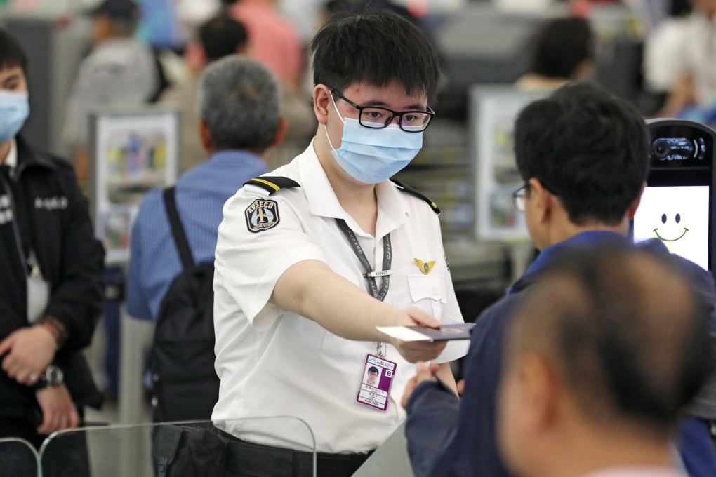 Staff at Hong Kong International Airport in Chek Lap Kok wearing surgical masks amid the outbreak of measles that has stricken the airport. Photo: SCMP Pictures