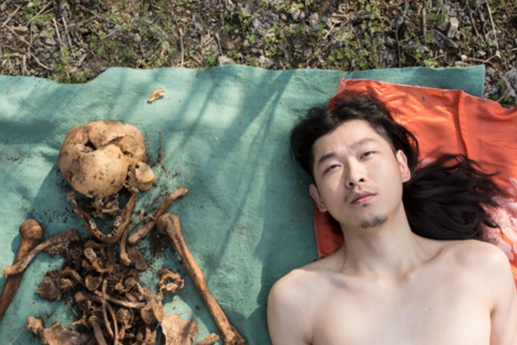 A Chinese artist has sparked widespread condemnation for posing naked with his father's decades-old remains. Photo: Artand.cn