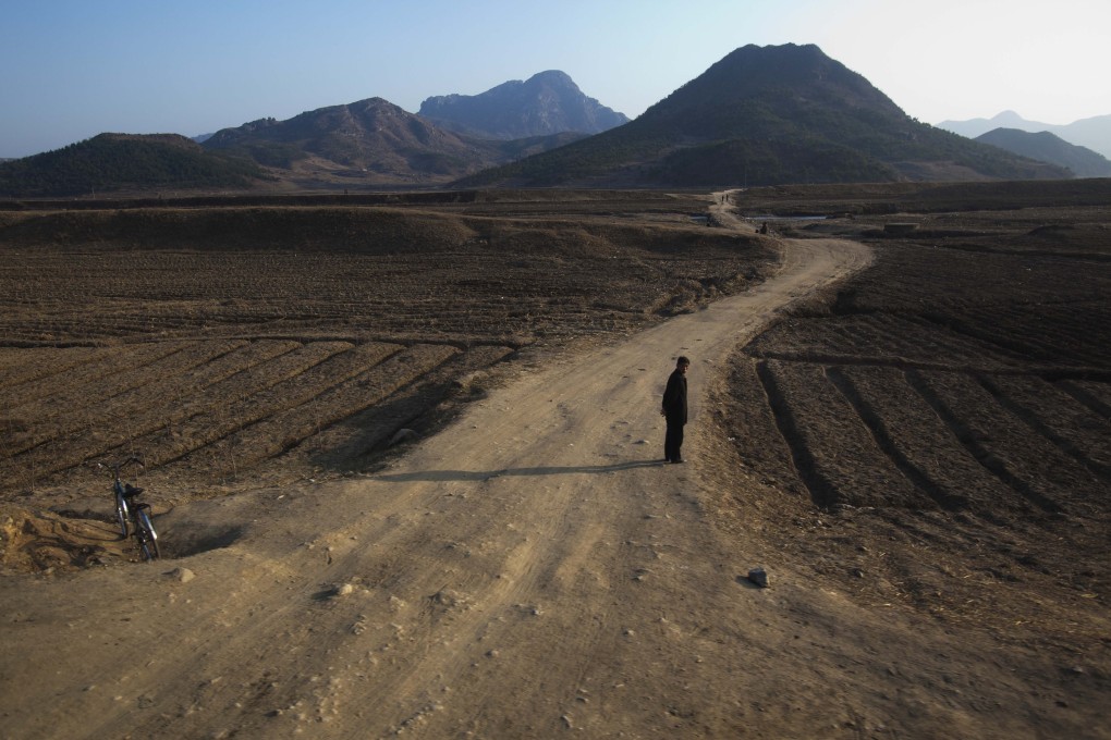 A North Korean official stands guard on a rural road. China expects a rise in the number of refugees crossing the border this summer amid a severe food shortage. Photo: AP