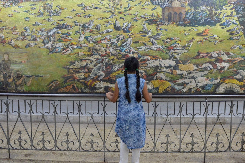 An Indian girl looks at a painting of the martyrs ahead of the 100th anniversary of the Jallianwala Bagh massacre in Amritsar. Photo: AFP