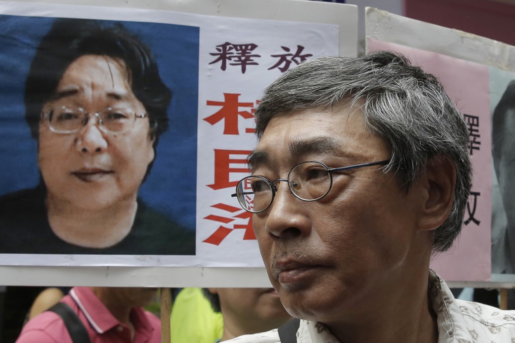 Lam Wing-kee, one of the Hong Kong booksellers who was detained on the mainland and subsequently freed, stands next to a placard with a picture of missing bookseller Gui Minhai (left) in front of his bookstore during a march in Hong Kong in October 2017. Photo: AP