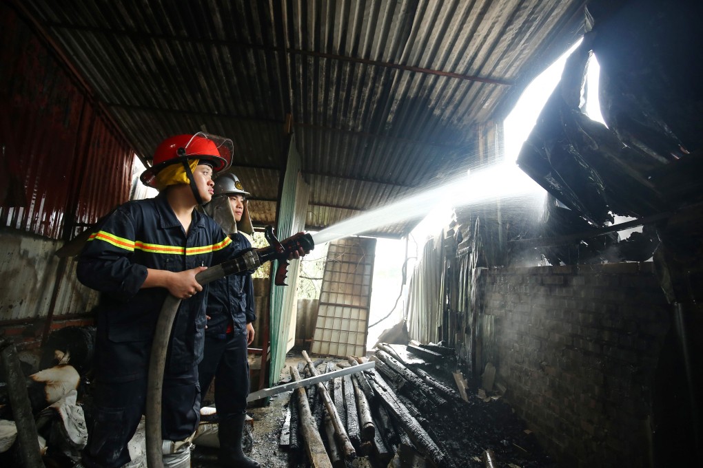Firefighters battling a blaze in a workshop complex in Hanoi. Photo: AFP