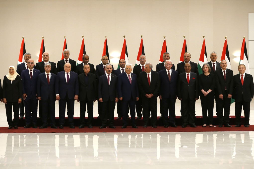 Palestinian President Mahmoud Abbas (seventh from right) poses for a group photograph with the members of the new Palestinian government in the Israeli-occupied West Bank town of Ramallah on Saturday. Photo: AFP