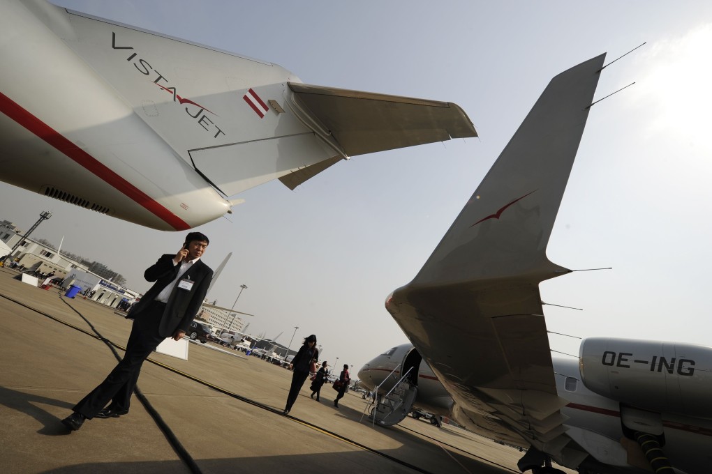 Visitors look at an aircraft from Vistajet, on left, and a Vistajet Bombardier aircraft at Honqiao International airport in Shanghai on March 27, 2012. Photo: AFP