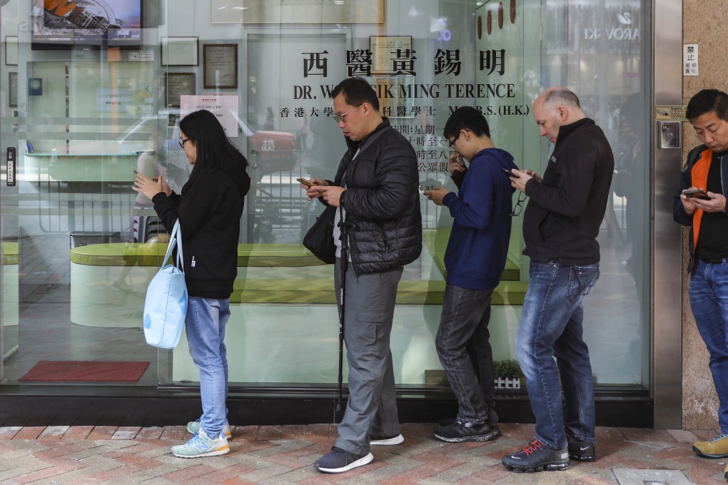 People queue up outside a clinic in Mong Kok. Blue Cross (Asia-Pacific) Insurance is using blockchain to verify and process medical claims of its clients. Photo: Sam Tsang