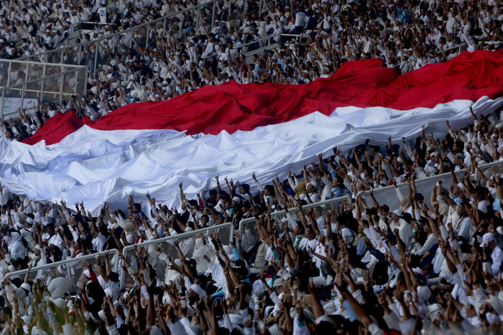 The Indonesian flag being held aloft during a campaign rally in Jakarta. Photo: EPA