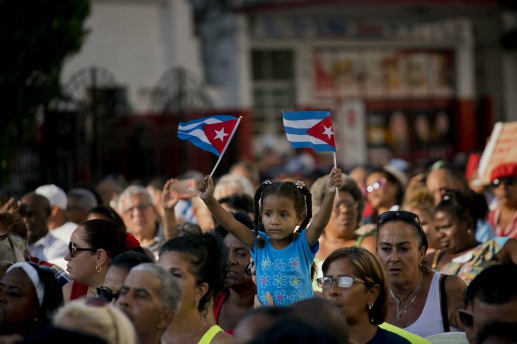 A girl waves Cuban flags during an event commemorating the 58th anniversary of Fidel Castro's declaration that the revolution he was leading in the 1950s was a socialist one. Photo: AP