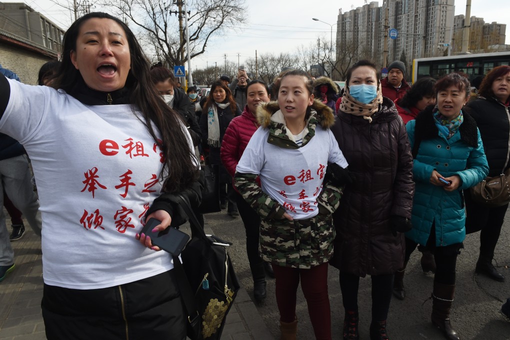 This photo taken on February 4, 2016 shows investors in Chinese online peer-to-peer lender Ezubao chanting slogans during a protest in Beijing. The protest came days after China announced that 21 people had been arrested on suspicion of defrauding around 900,000 people of more than 50 billion yuan, after Ezubao turned out to be a giant Ponzi scheme. Photo: Agence France-Presse