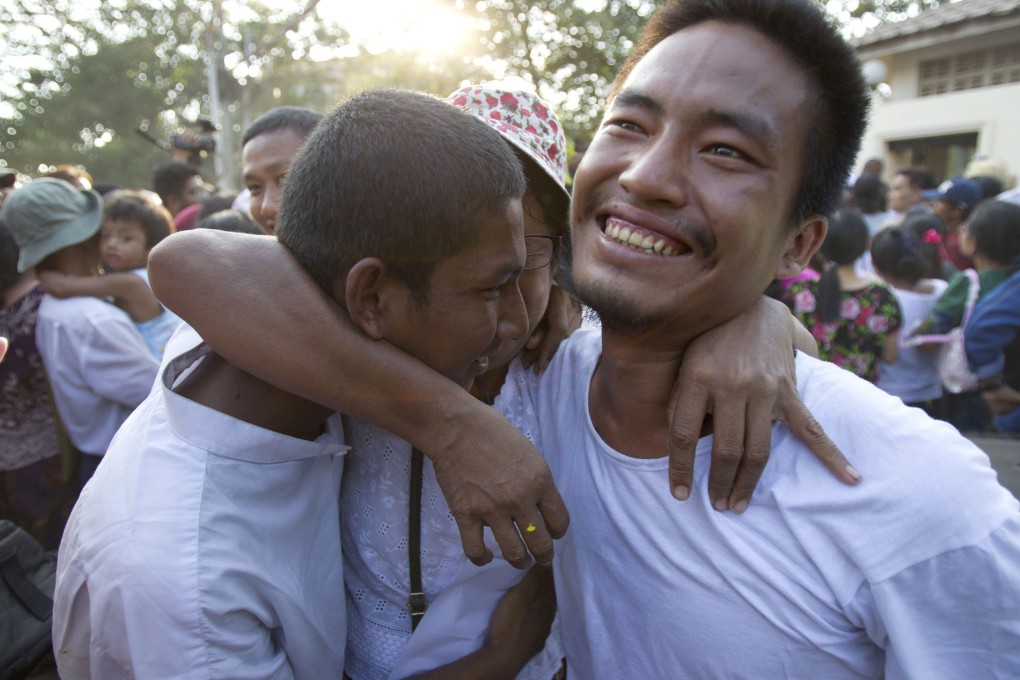 Two men celebrate with their mother after being released from Insein prison. Photo: AP Photo