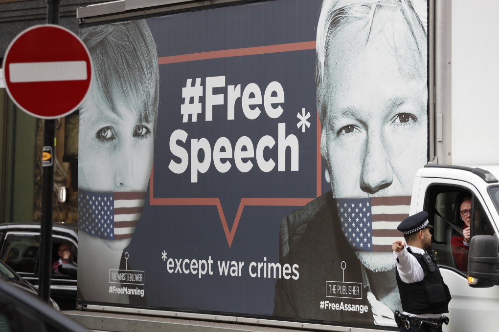A policeman directs a van with a “Free Speech” placard and the images of Wikileaks founder Julian Assange and whistle-blower Chelsea Manning on its side, near the Ecuadorian Embassy, in London. Photo: AP