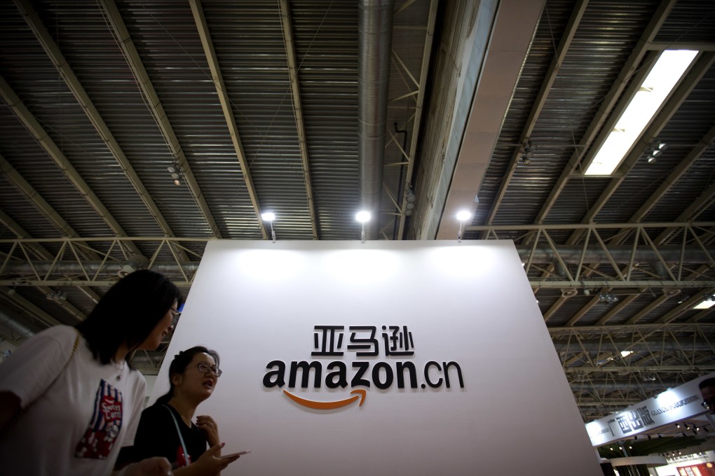 Visitors walk past a logo for Amazon China at the Beijing International Book Fair in 2017. Photo: AP