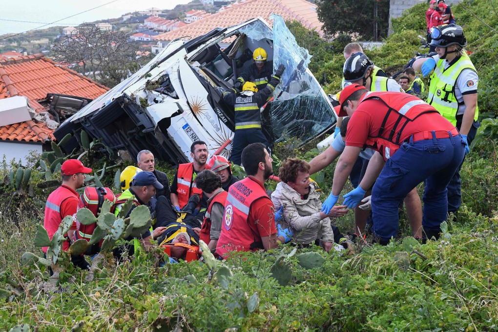 Firefighters help victims of a tourist bus that crashed on Wednesday on the Portuguese island of Madeira. Photo: AFP