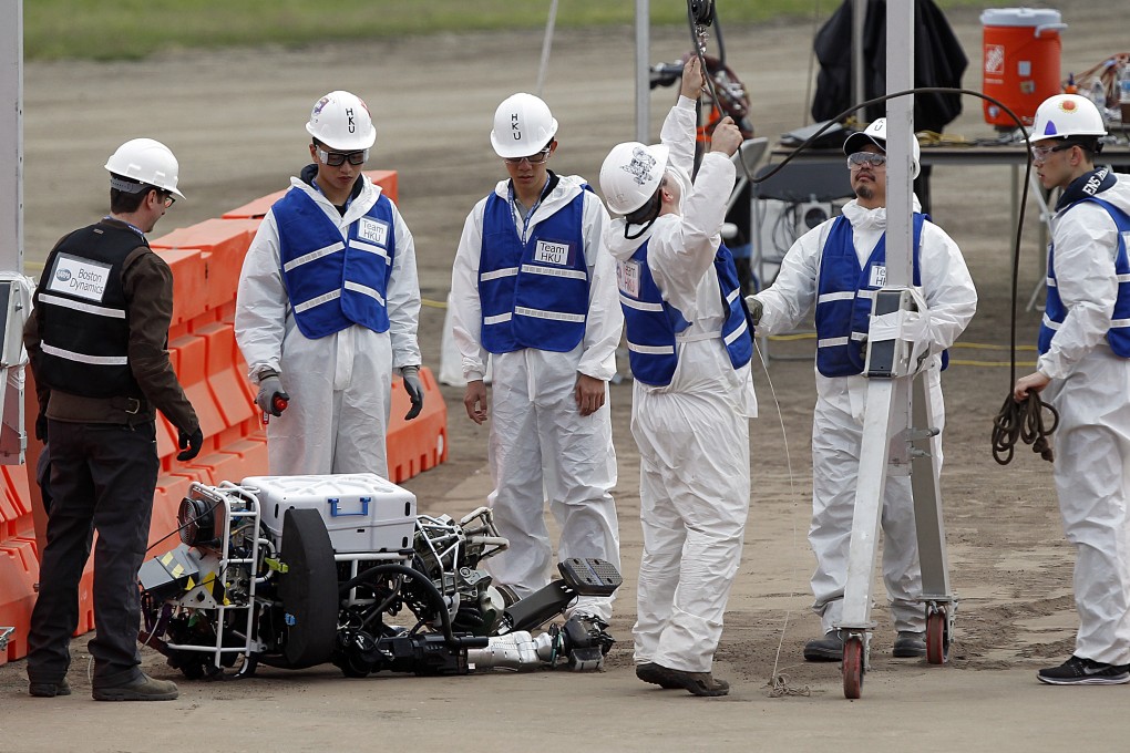University of Hong Kong researchers work to get their robot, Atlas, back on its feet after it fell during the first stage in the US Defense Advanced Research Projects Agency Robotics Challenge in Pomona, California in June 2015. Photo: AP