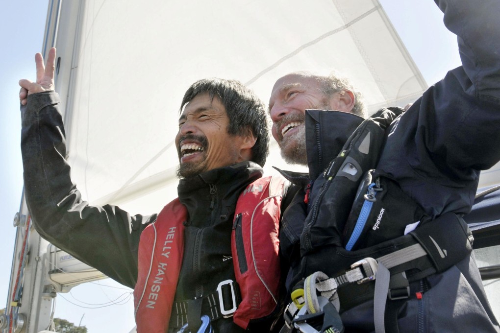 Mitsuhiro Iwamoto celebrates with navigator Doug Smith after completing the voyage. Photo: Reuters