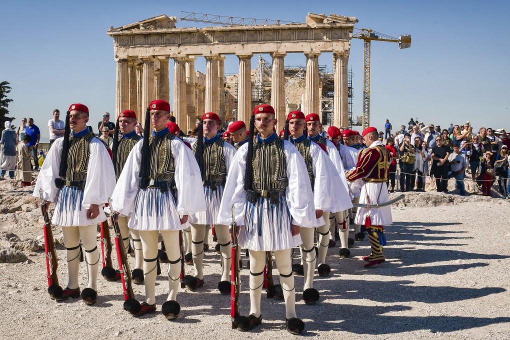 Presidential guards present arms in front of the Parthenon temple during the ceremony for the annual anniversary of the liberation of Athens from Nazi occupation, at the Acropolis Hill, in Athens. Photo: EPA