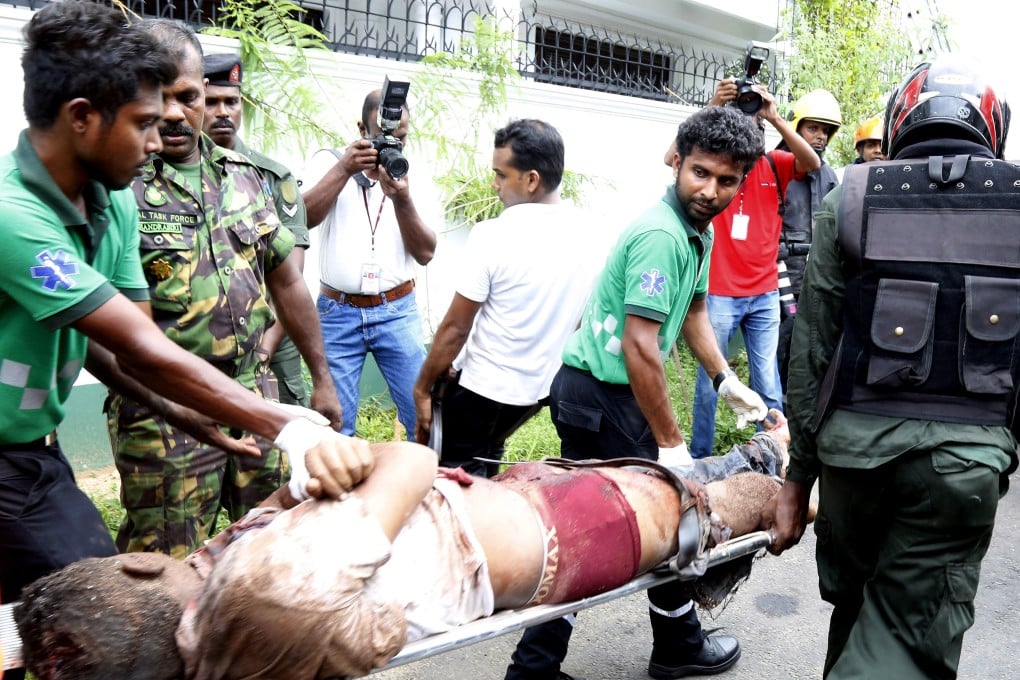 A victim of the bomb blasts in Colombo is carried off by security personnel. Photo: EPA