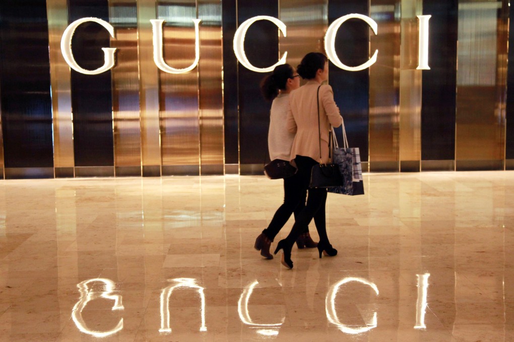 Chinese shoppers walk past a Gucci shop in Nanjing, east China's Jiangsu province. Photo: AFP