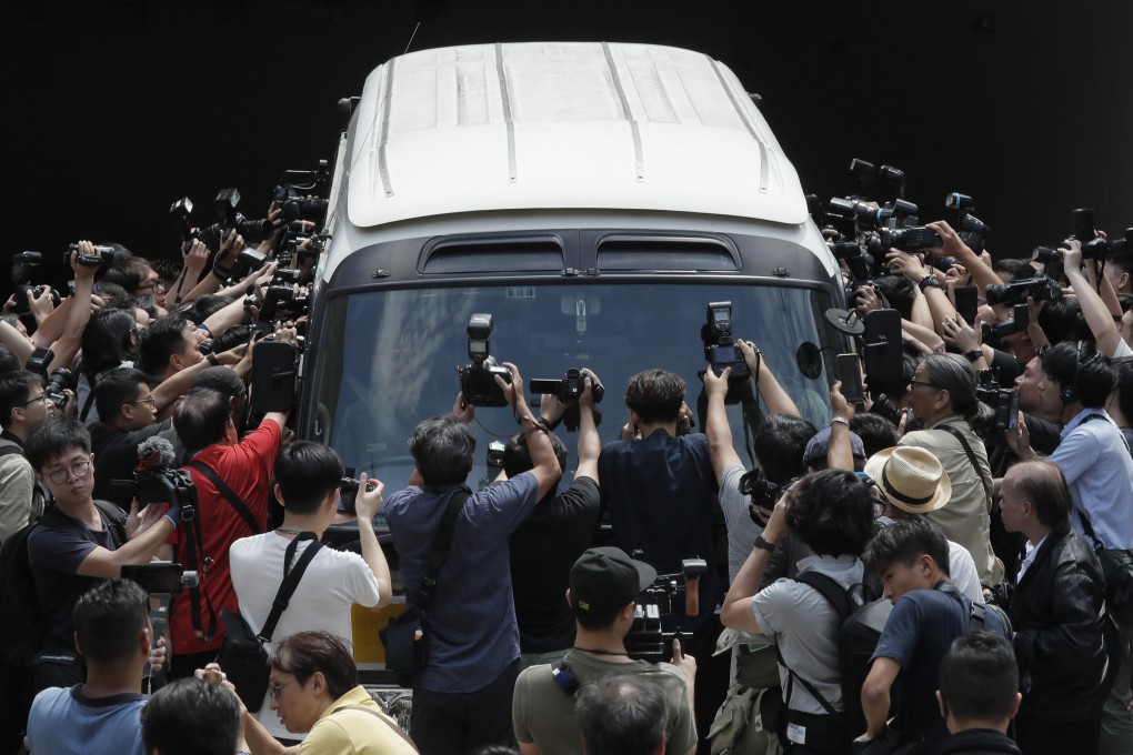 Photographers scramble around a prison van carrying the Occupy Central leaders Chan Kin-man, Benny Tai, Raphael Wong and Shiu Ka-chun at a court in Hong Kong. Photo: AP