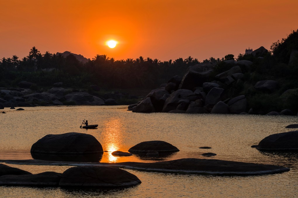 Sunset over Tungabhadra river and part of the ruins of the former Vijayanagar empire at Hampi in Karnataka, India. Photo: Alamy