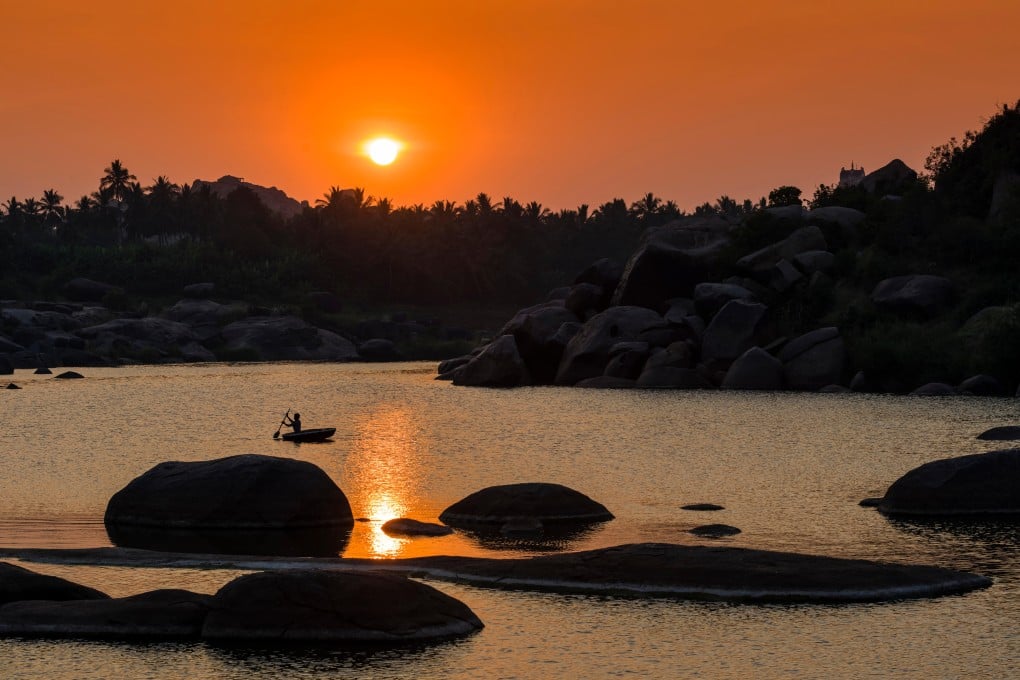 Sunset over Tungabhadra river and part of the ruins of the former Vijayanagar empire at Hampi in Karnataka, India. Photo: Alamy