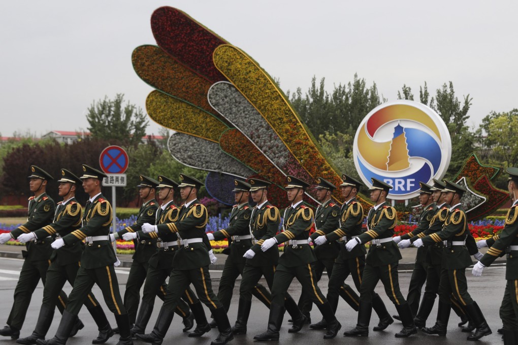 Chinese paramilitary police officers march past a Belt and Road Forum display at Beijing International Airport. Photo: EPA-EFE