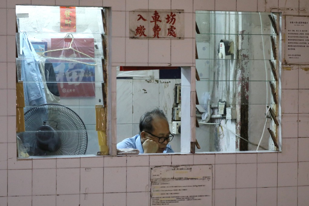 A security guard works in a building in Tai Wai. Security guards often work 12-hour shifts, leaving them little time for anything more than sleep. Photo: Sam Tsang