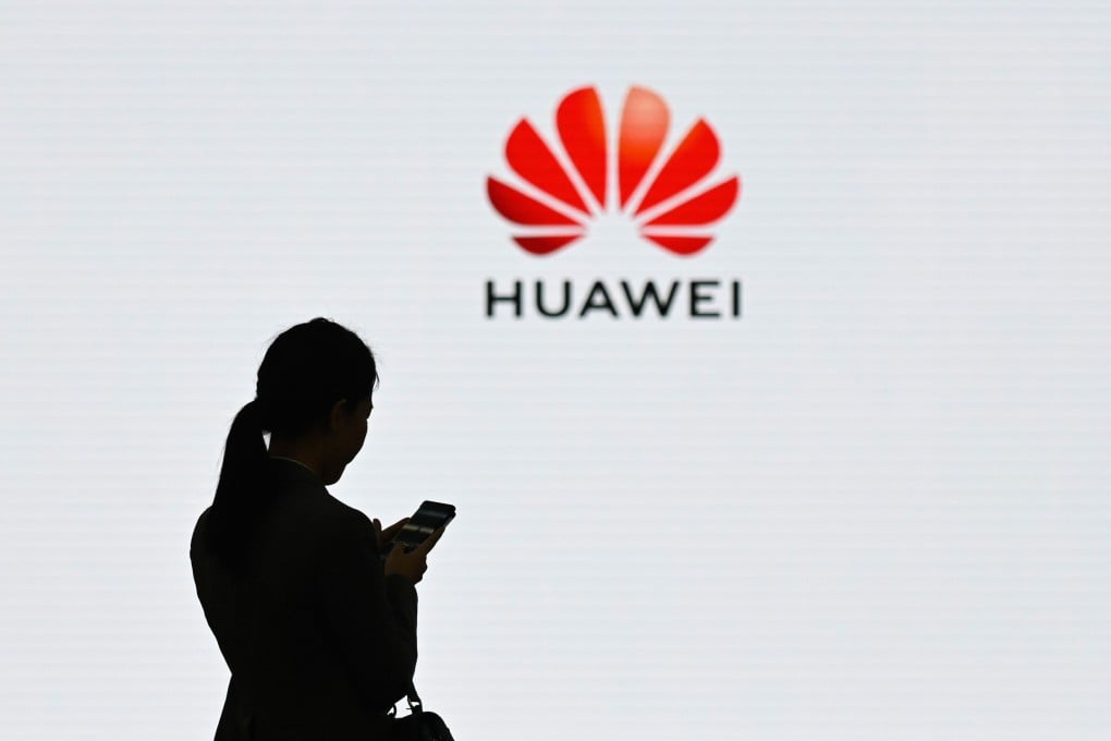 A staff member of Huawei uses her mobile phone at the Huawei Digital Transformation Showcase in Shenzhen. Photo: AFP